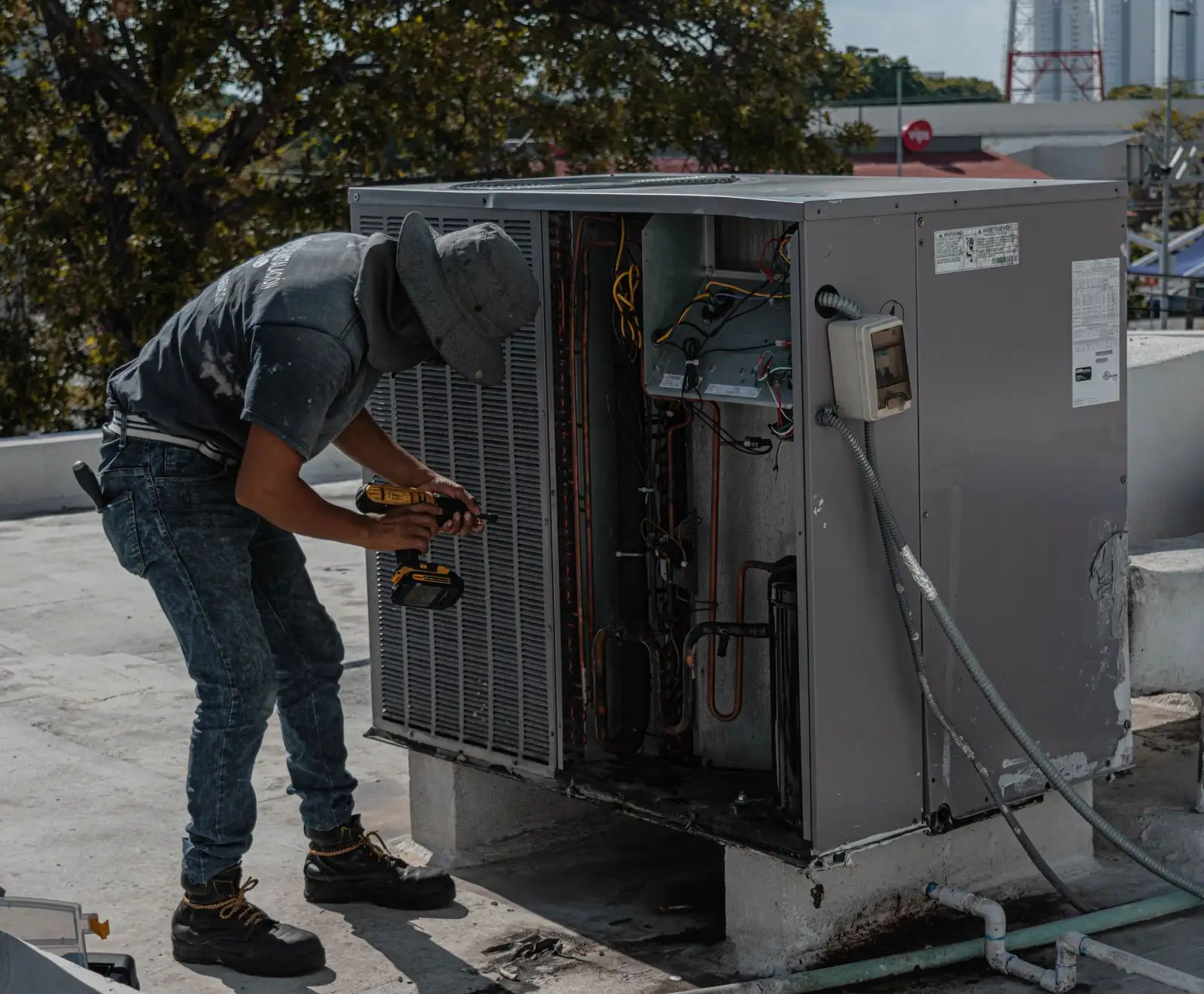 Un técnico trabaja en una unidad de aire acondicionado